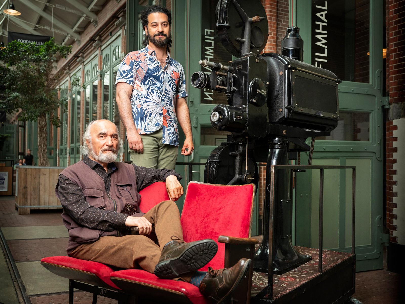 Mani Nickpour with his father Saeid Nickpour beside a vintage film projector